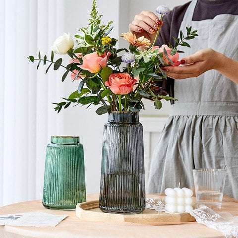 Vase rayé de couleur avec bordure liseré doré en Verre présentation du modèles couleur vert S et Gris M avec bouquet de fleurs sur une table mise en scène.