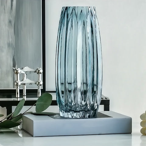 Vase Simple Incurvé Vert Transparent en verre, présentation modèle Vert M sans fleurs sur un livre, sur une table.
