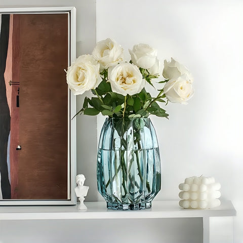 Vase simple incurvé vert ou transparent en verre, présentation du modèle S vert avec bouquet de roses sur un buffet.