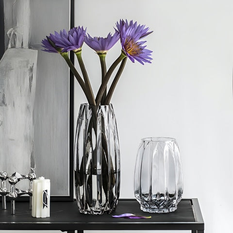 Vase simple incurvé vert ou transparent en verre, présentation des modèles S et M transparent avec fleurs sur une table.