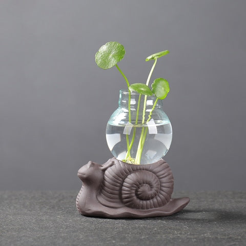 Vase Soliflore Mini Pot Thème Pastoral en verre et céramique, présentation du style C modèle escargot avec plante verte sur une table.