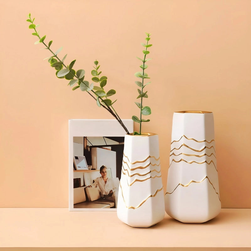 Vase Sophistiqué Polygone Blanc et Doré en céramique présentation et mise en scène et modèles M vide et S avec avec tige d'eucalyptus sur une table.