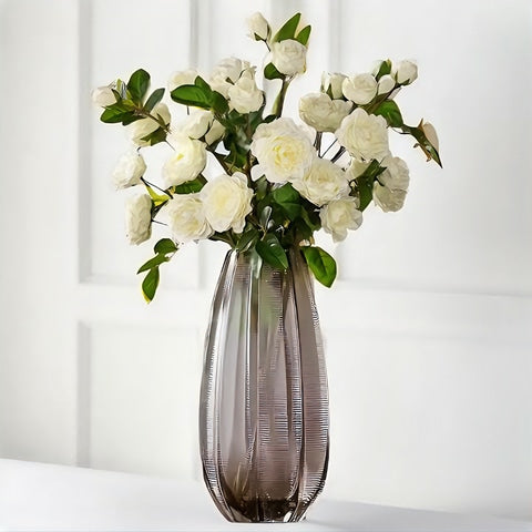 Vase strié coloré marron transparent en verre, modèle S avec bouquet de roses blanches.