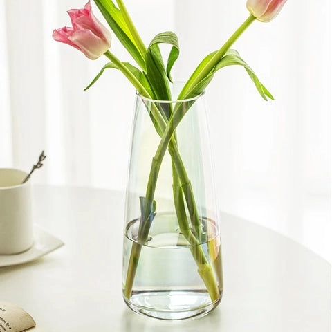 Vase translucide reflet irisé en verre modèle Transparent avec tulipes sur une table blanche.