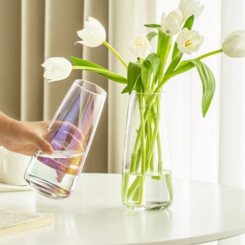 Vase Translucide Reflet Irisé en verre présentation des modèles Transparents, un tenu en main sans fleurs et l'autre sur une table avec tulipes blanches.