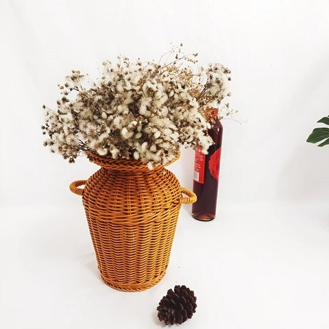 Vase Tressé Artisanal avec Anses en rotin présentation avec bouquet de fleurs séchées et ornements.