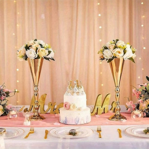 Vase trompette mariage centre de table couleur or en métal, mise en scène avec bouquets de roses blanches.