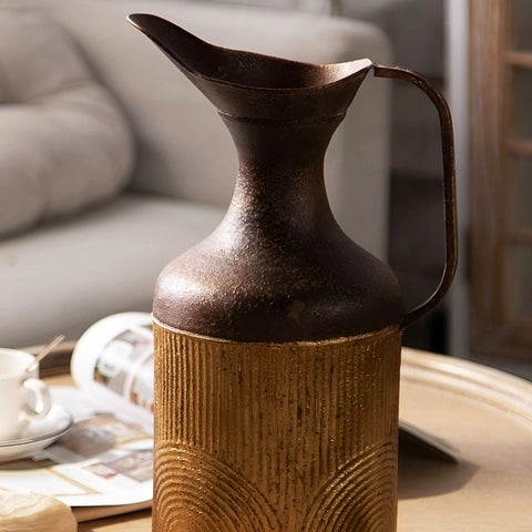 Vase Vieilli Pichet Bicolore en Métal sans fleurs sur une table vue de près