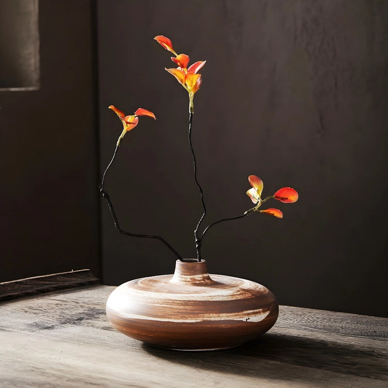 Vase Vintage Poterie Ikebana en Céramique, présentation modèle marron avec fleurs artificielles sur une table.