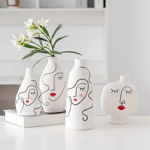 Vase visage femme peint à la main en céramique, présentation de tous les modèles sur une table.