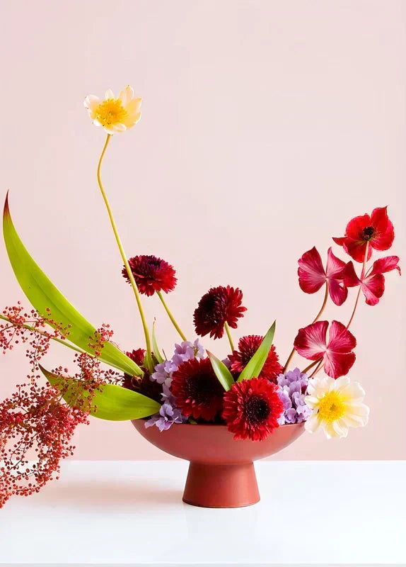 Présentation Vase violet Ikebana avec composition florale sur une table