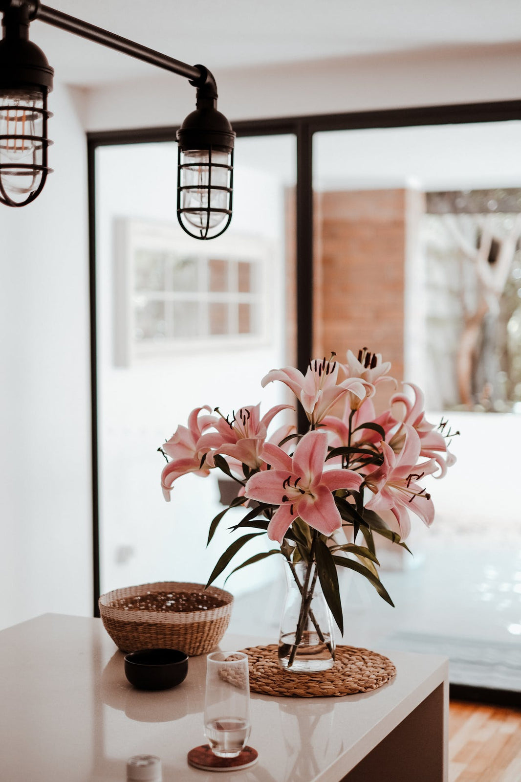 Vase transparent avec bouquets de fleurs rose avec lumière et baie vitréumière 