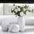 Plusieurs vases en porcelaine avec fleurs blanches posés sur une table basse.