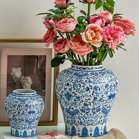 Présentation de deux vases chinois bleu et blanc motif fleurs avec fleurs sur une table.