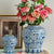 Présentation de deux vases chinois bleu et blanc motif fleurs avec fleurs sur une table.