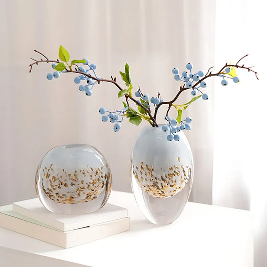 Petit Vase Luxueux Fond Marin, présentation des modèles rond et ovale avec branches de baies bleues sur une table.