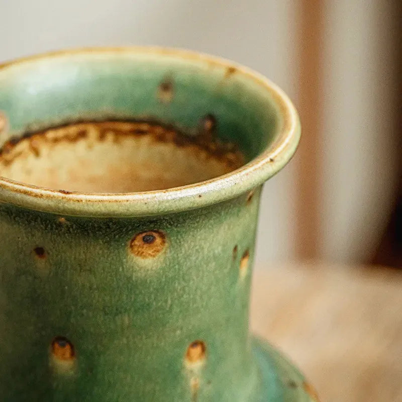 Petit vase vintage vert vieilli, détails des motifs et du col vu de près.