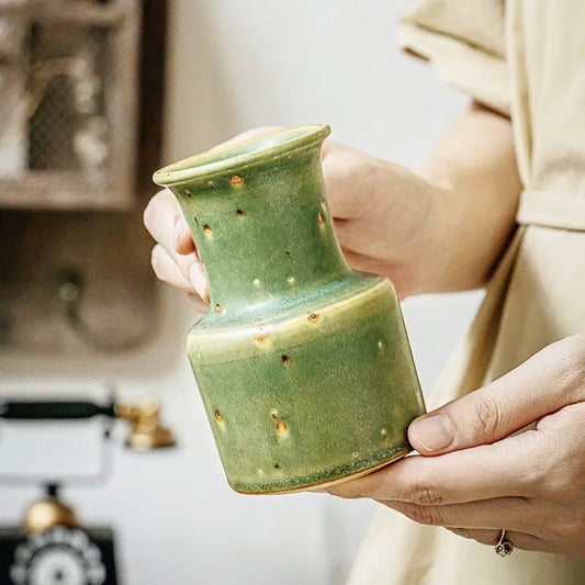 Petit Vase Vintage Vert Vieilli, présentation tenu en main sans fleurs.