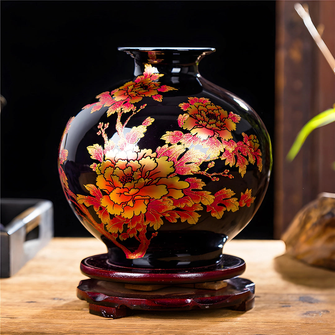 Présentation d'un petit vase chinois ancien noir avec des motifs floraux en céramique, avec socle, sur une table en bois.