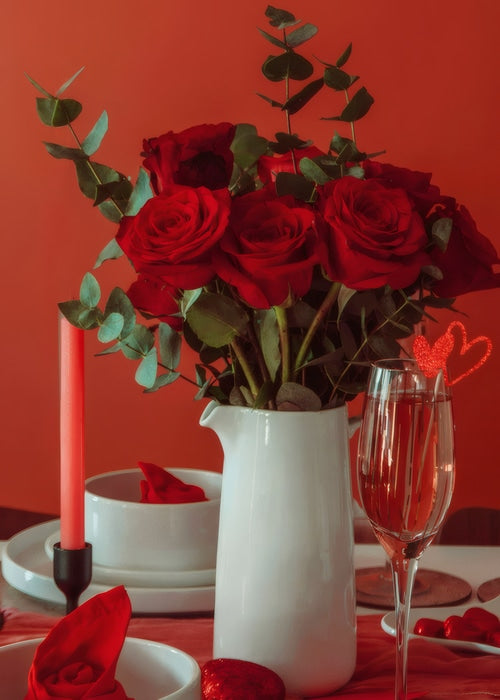 Présentation d'un vase cruche blanc en céramique avec bouquet de roses, mise en scène sur une table pour la Saint Valentin.