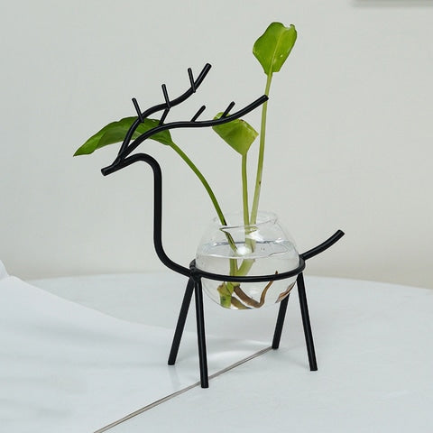 Soliflore design cerf majestueux présentation du modèle A noir avec plante verte sur une table blanche.
