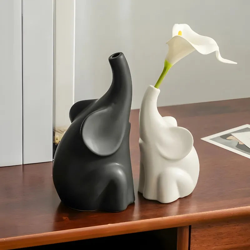 Soliflore Éléphant Duo Noir et Blanc présentation des modèles noir et blanc avec fleur artificielle sur un meuble.