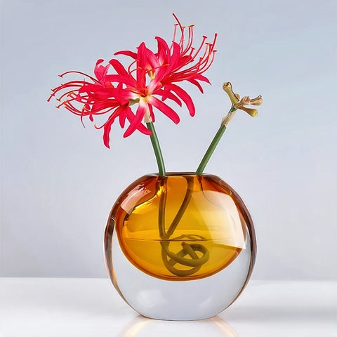 Soliflore rond transparent et coloré en verre présentation du modèle Ambre avec fleurs sur table