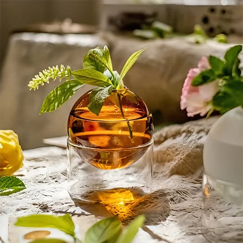 Soliflore sphérique sur socle tubulaire en verre présentation du modèle orange avec fleur