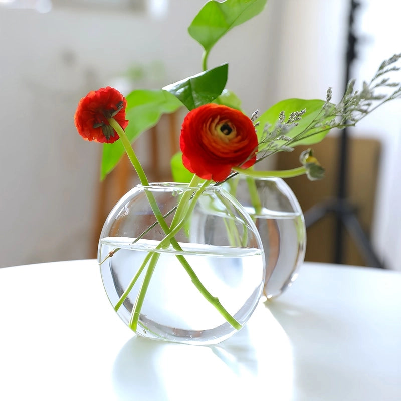 Soliflore Sphérique Transparent sur Socle en Bois, présentation du contenant avec fleurs sur une table blanche.