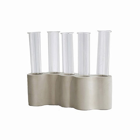 Soliflore avec tubes ikebana sur fond blanc.