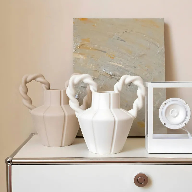 Vase Amphore Moderne Anses Torsadées présentation des modèles beige et blanc sur un meuble sans fleurs.