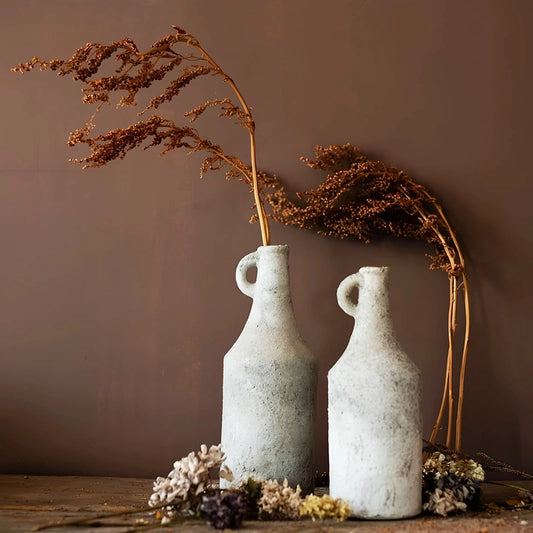 Vase Ancien Forme Bouteille avec Anse présentation de modèles L avec fleurs séchées et M sans fleurs sur une table en bois.
