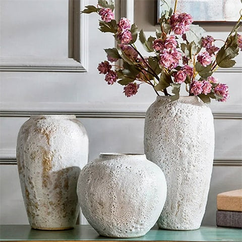 Vase artisanal effet pierre poreuse en céramique présentation des modèles S M et L avec fleurs sur une table