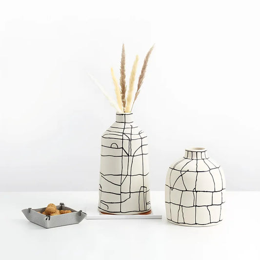 Vase Artistique Blanc aux Lignes Abstraites Noires présentation des modèles A avec fleurs séchées et B sans fleurs sur une table blanche.