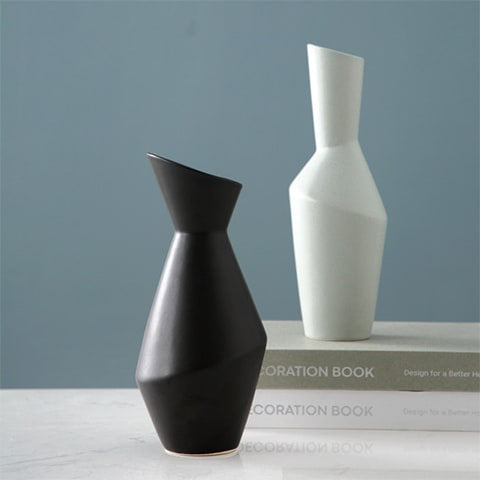 Vase asymétrique nordique en céramique présentation des modèles Noir et Gris sur une table blanche mise en scène