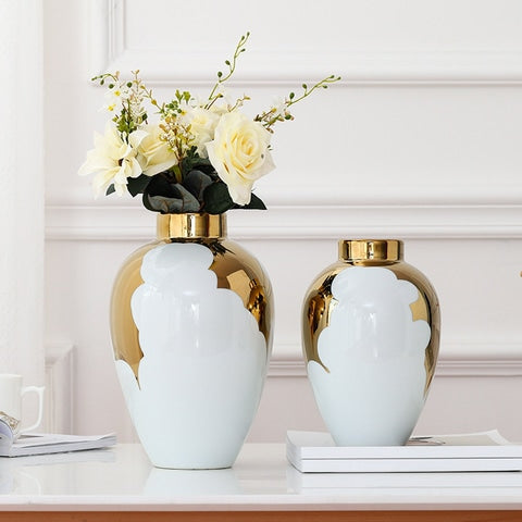 Vase blanc et or motif feuilles de houx présentation des modèles Grand avec fleurs et petit sans fleurs sur un livre