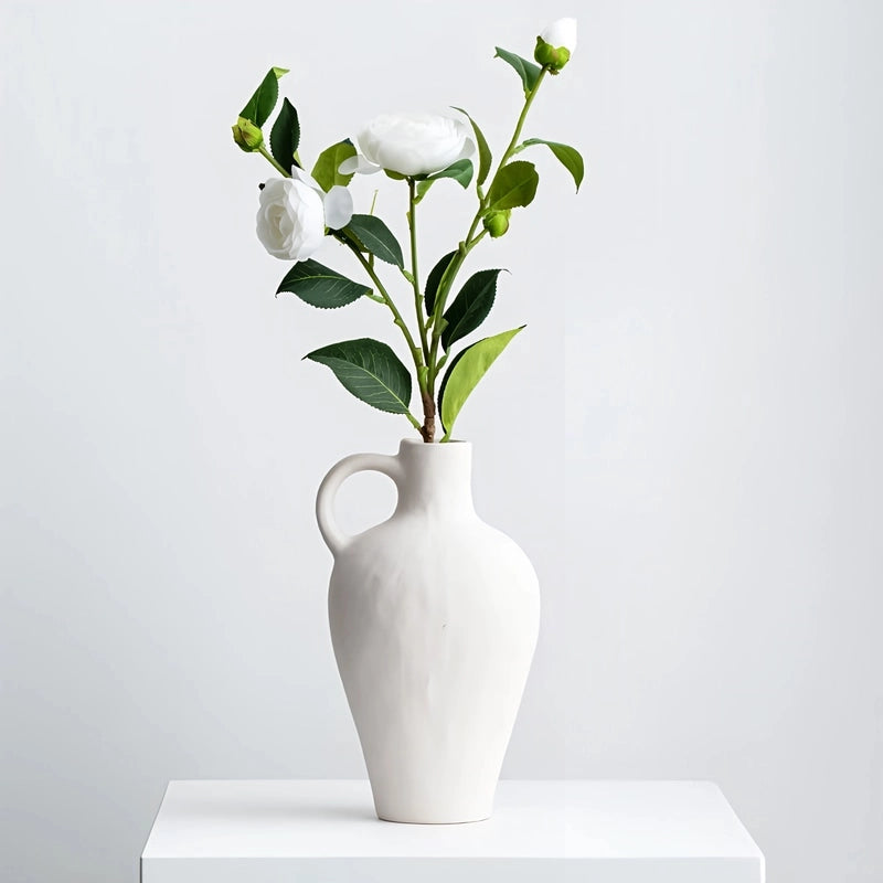 Vase Blanc Moucheté Forme Cruche avec Anse présentation avec bouquet de fleurs blanches.