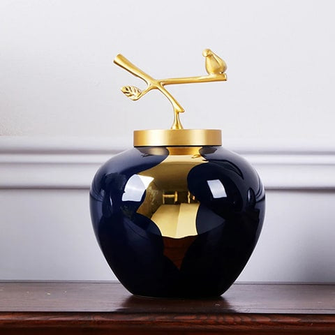 Vase bleu et or moderne luxueux présentation du modèles S avec son couvercle sans fleurs sur une table