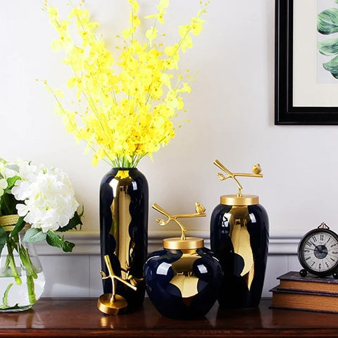 Vase bleu et or moderne en céramique présentation des modèles L avec fleurs jaune S et M sans fleurs sur une table en bois