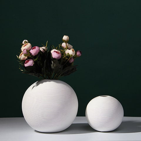 Vase boule blanc minimaliste en céramique présentation des modèles M  avec bouquet de fleurs et S sans fleurs sur une table blanche