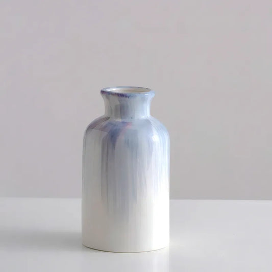 Vase Bouteille Blanc et Bleu Peint à la Main, présentation du modèle A sans fleurs sur une table blanche.