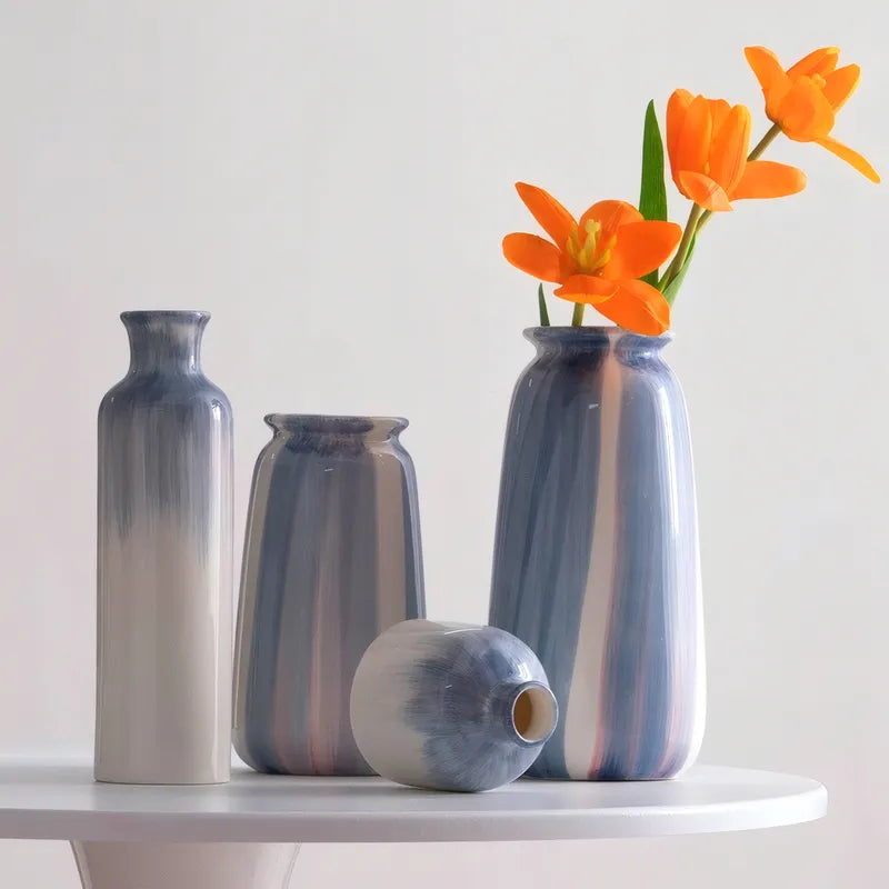 Vase Bouteille Blanc et Bleu Peint à la Main, présentation du modèle B et A mise en scène sans fleurs sur une table blanche.