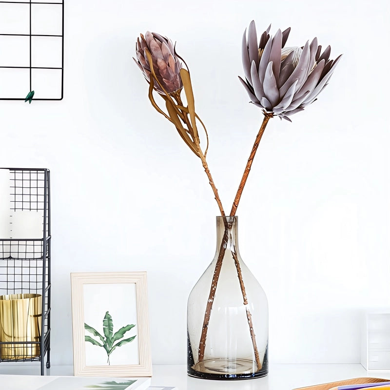 Vase Bouteille Verre Bullé Coloré en verre, présentation sur une table du modèle A marron avec fleurs séchées.