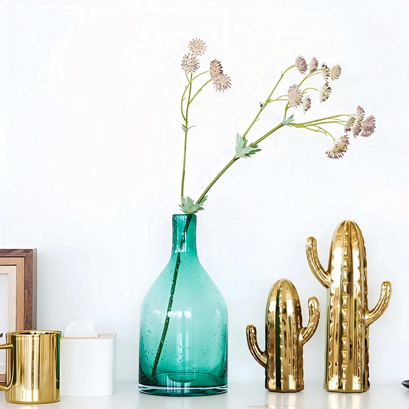 Vase Bouteille Verre Bullé Coloré en verre, présentation sur une table du modèle A vert avec fleurs.
