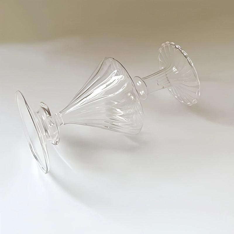 Vase carafe chic transparent en verre, couché sur un plan de travail, sans fleurs, détails artisanaux.