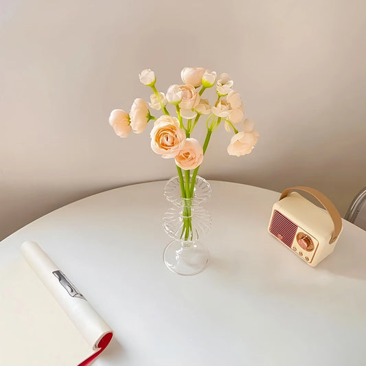 Vase carafe chic transparent en verre présentation avec bouquet de pivoines roses sur une table.