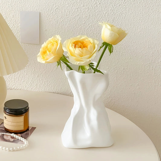 Vase Créatif Froissé Design Original présentation du modèle blanc avec roses jaunes sur une table.