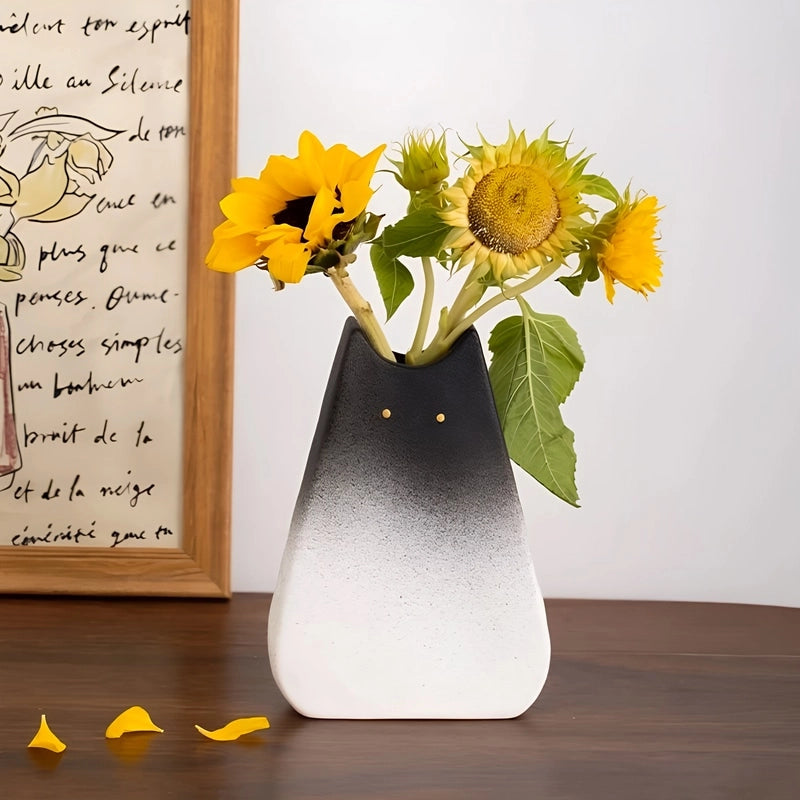 Vase Créatif Silhouette de Chat Original présentation du modèle Grand noir et blanc avec bouquet de fleurs jaunes sur un meuble en bois.