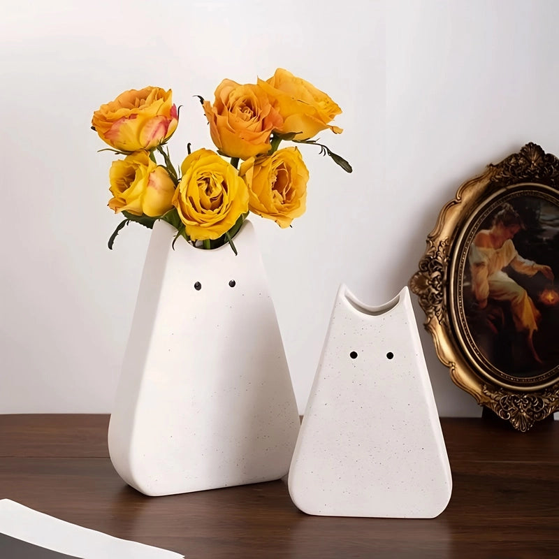 Vase Créatif Silhouette de Chat Original présentation des modèles Grand avec fleurs et Petit blanc sans fleurs sur un meuble en bois.