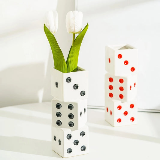 Vase Dés Colorés Superposés, présentation des modèles noir avec une tulipe et rouge sans fleurs sur une table blanche.